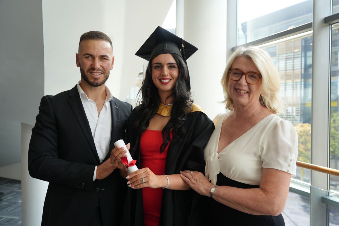 Image showing graduate posing with two others. 